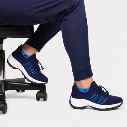 Navy blue knit lace-up sneakers on a person, white sole with blue grid detail